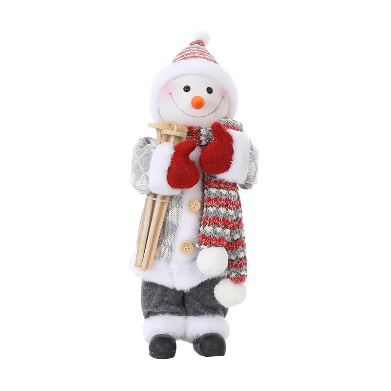 Bonhomme de neige décoratif en bonnet et écharpe rouge gris, gants rouges, tenant des skis en bois