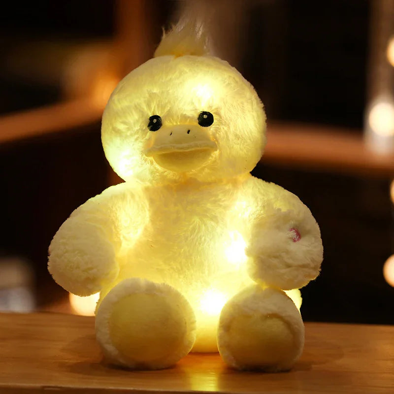 Peluche canard jaune lumineux avec lumières intégrées posé sur une surface en bois