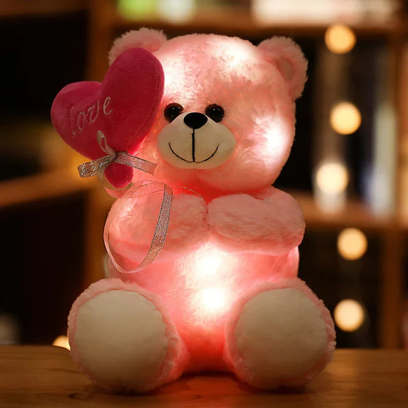 Peluche ours rose lumineux tenant un cœur rouge avec le mot love, décor chaleureux en arrière-plan
