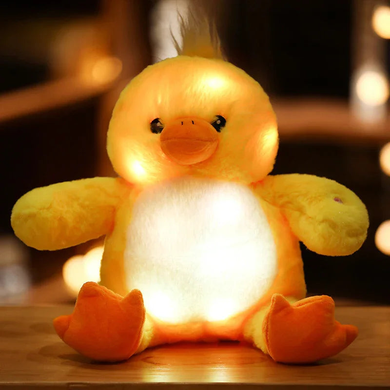 Peluche canard jaune lumineux avec lumière intégrée, assis sur une surface en bois